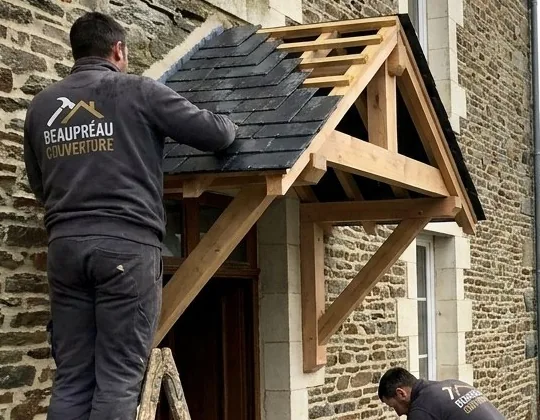 Couvreur posant des ardoises sur un auvent en chêne neuf, maison en schiste à Beaupréau-en-Mauges
